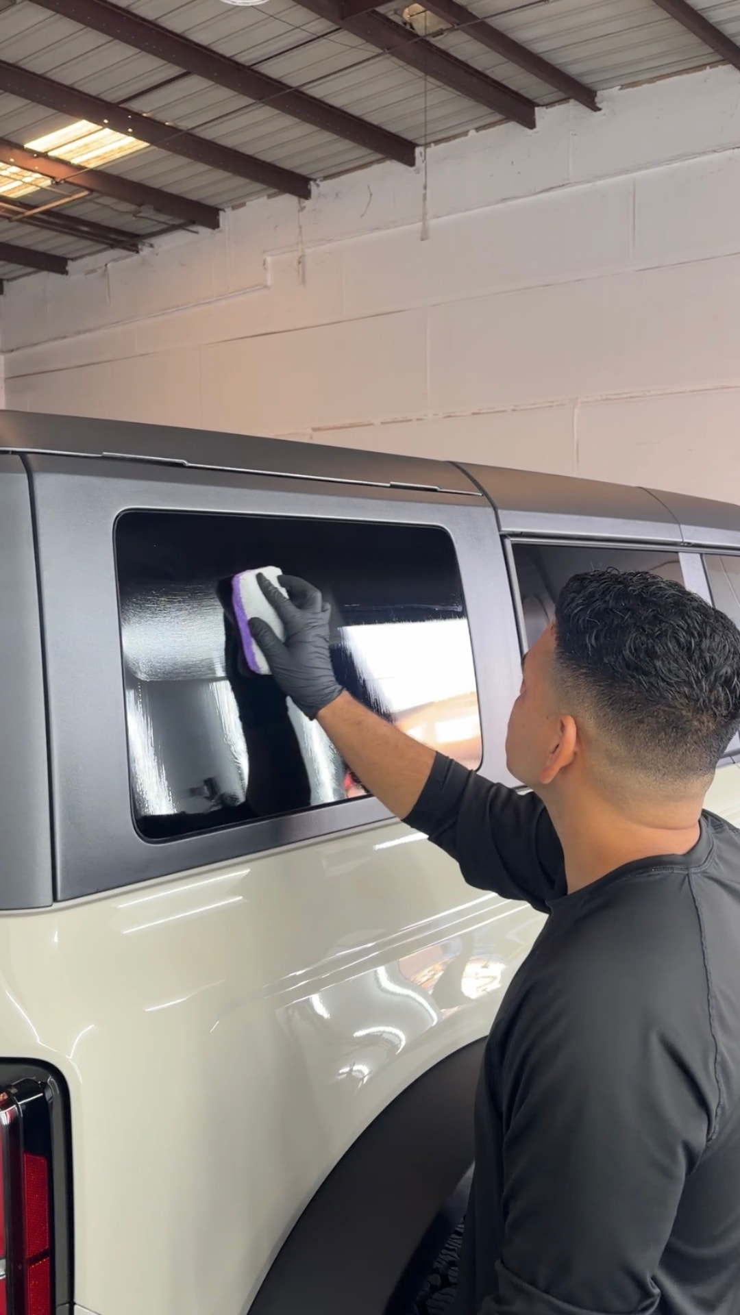 Black sedan fender with water beading after ceramic coating application